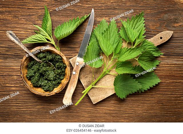 Nettle fresh green leaves on a wooden background