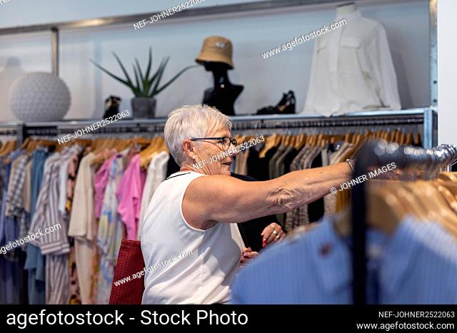 Senior woman doing shopping in clothes shop