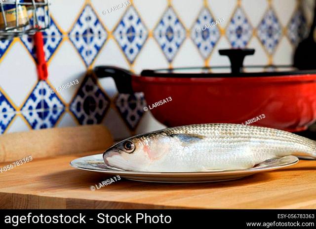 Mullet striped mullet contains omega-3 acids, vitamins and minerals. Mullet lying on the plate ready for cooking. A dietary product
