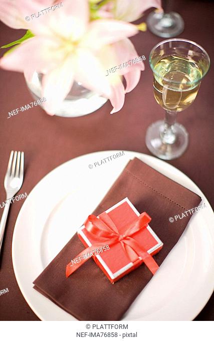 Table laid with a little red box on a plate