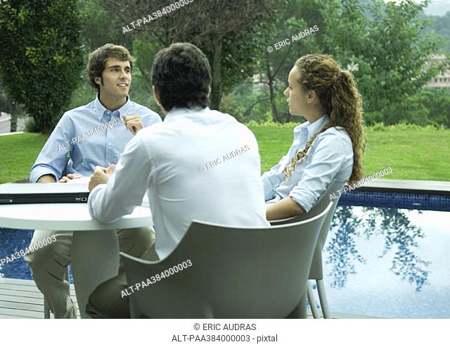 Casually dressed young executives working near edge of pool