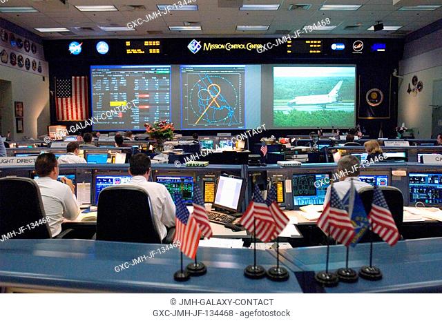 Flight controllers watch the big screens from their consoles in this overall view of the Shuttle (White) Flight Control Room of Houston's Mission Control Center...