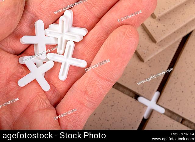 White crosses used for laying gres tiles. Accessories and tools needed for construction workers. Bright background