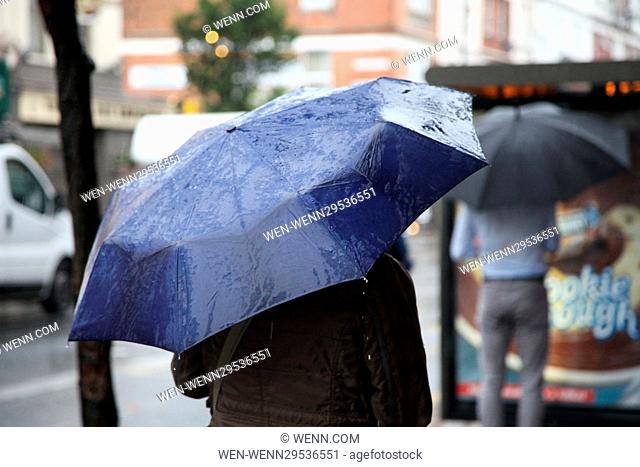 Commuters and shoppers in north London struggle on their way to work as the rain arrives to break the heatwave. Featuring: Atmosphere Where: London