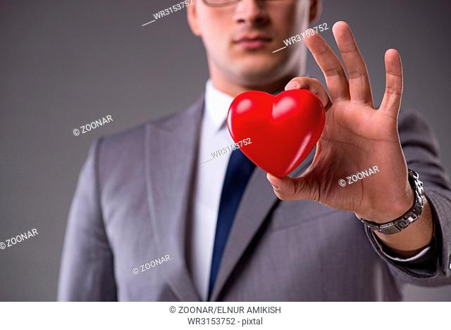 Businessman holding red heart in love concept