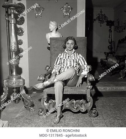 Giovanna Ralli sitting in an armchair. The actress Giovanna Ralli is sitting in an baroque armchair on the inside of a room with gaudy golden furniture