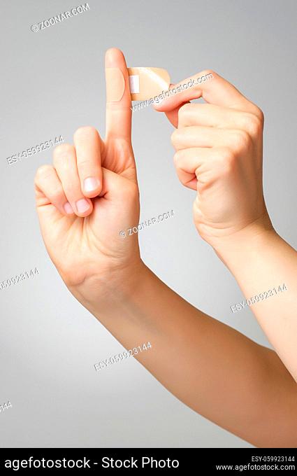 Woman putting a plaster on her index finger