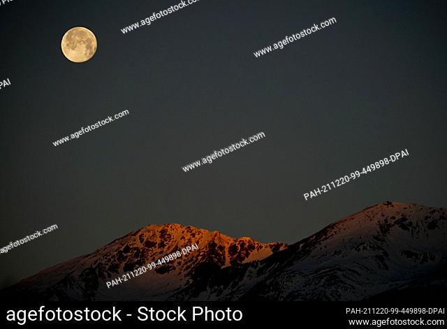 20 December 2021, Italy, Brixen: The moon stands in the morning hours above the village of Brixen in South Tyrol near the Liffelspitze in the east