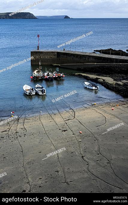 High angle view of fishing boats moored in harbour at low tide