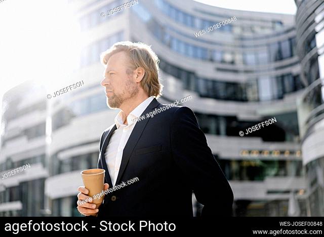Businessman with takeaway coffee in the city