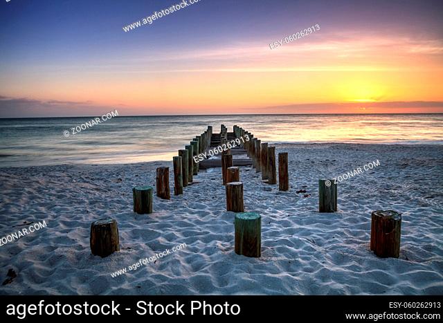 Ruins of the old Naples Pier at sunset on the ocean on the beach of Naples, Florida