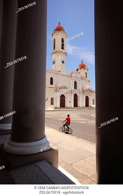 Man riding on a bike in front of the Purisima Concepcion Cathedral in Jose Marti Park, Cienfuegos, Cuba, West Indies, Central America