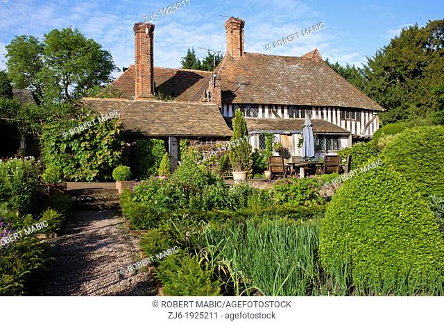 View of the garden, kitchen garden, box topiary, gravel path, house and relaxing area, Bexon Manor Kent England