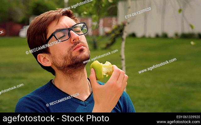 Employee Taking Break Work. Young man Eating a apple as snack. Heathy food Concept