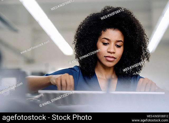 Female professional working with printing machinery in industry