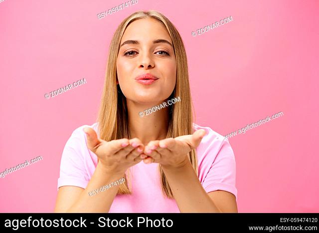 Spreading love to world. Portrait of charming sensual and tender romantic girlfriend holding palms over chest folding lips raising head and sending air kiss at...