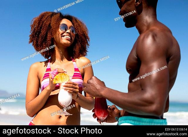 Mixed race couple with cocktails on the beach
