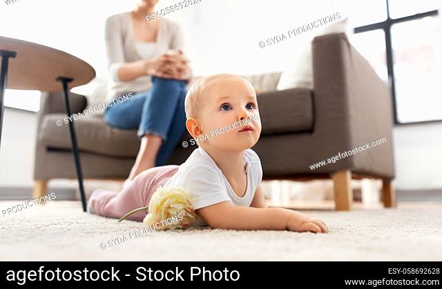 mother and baby crawling on floor at home