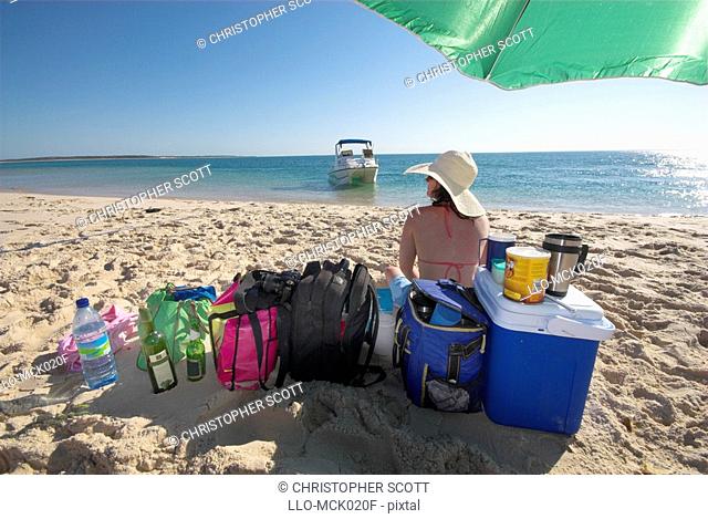Woman Sitting on the with Cooler Bags and Luggage  Bazaruto Archipelago, Mozambique