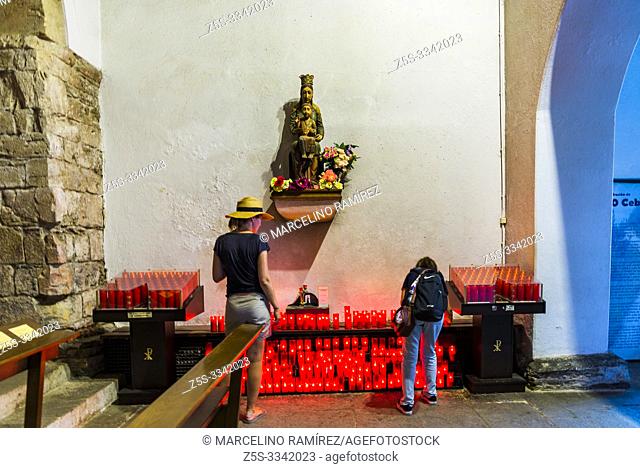 Two pilgrims next to the votive candles. The Royal St. Mary's Church, also known as the Church of St. Benedict, was built in O Cebreiro in 1965â