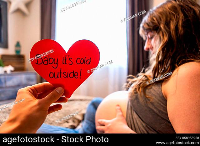 A conceptual message with shallow depth of field, pregnant woman prepares for home birth in february, winter baby, valentine gift, family love