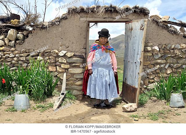 Portrait of a woman in traditional dress of the Quechua in a yard gate, Bolivian Altiplano highlands, Departamento Oruro, Bolivia, South America