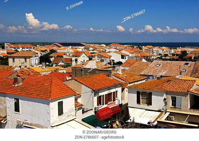 Blick über die roten Ziegelsteindächer der Häuser von Saintes-Maries-de-la-Mer, Camargue, Frankreich / View across the red tiles of the roof tops of the houses...