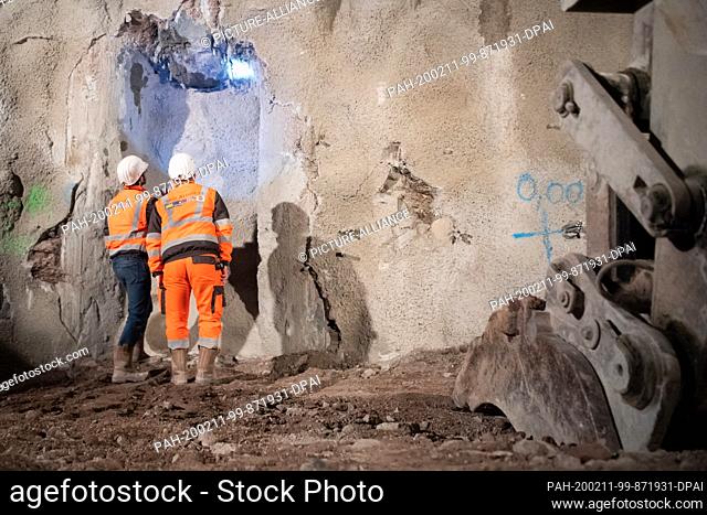11 February 2020, Baden-Wuerttemberg, Stuttgart: Construction workers stand at the stop wall in the Fildertunnel and discuss the tunnel breakthrough