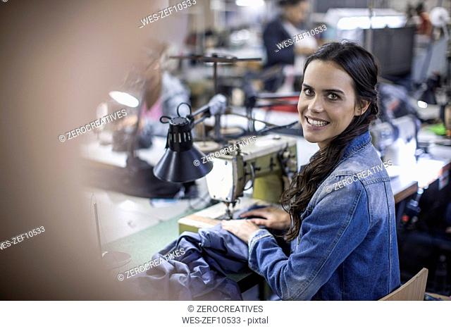 Seamstress in factory sewing clothes