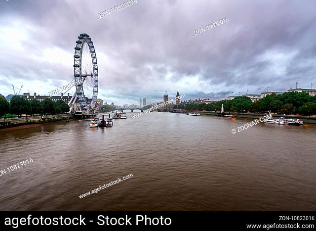 LONDON - OCTOBER 6: London Eye and Westminster Palace on October 6, 2014 in London. The largest Ferris Wheel in Europe, structure of the London Eye is 135...