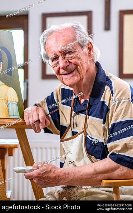 PRODUCTION - 28 June 2021, Bavaria, Pocking: Wilfried Klaus, actor, sits in front of an easel in his studio. The actor has appeared in a large number of German...
