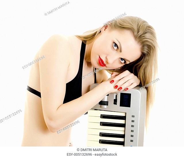 Woman in black swimsuit posing with Piano keyboard. Isolated on white