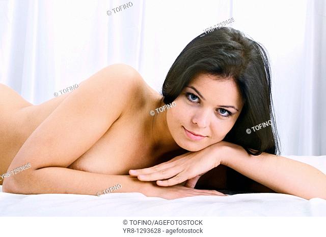 Portrait of young nude female in bed