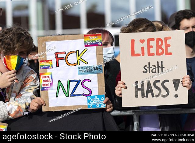 17 October 2021, Saxony, Dresden: Demonstrators hold a cardboard sign with the inscription ""Love not hate!"" during the counter-demonstration on the 7th...