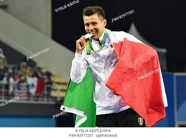 Silver medalist German Sanchez of Mexico bites his medal during the medal ceremony of the Men's 10m Platform Final of the Diving event during the Rio 2016...