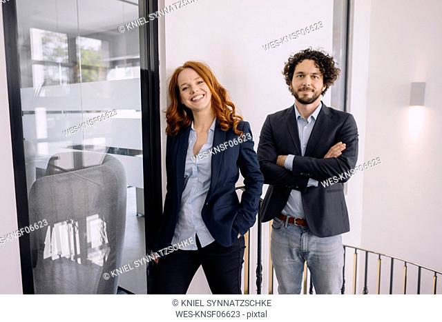 Portrait of confident businessman and businesswoman in office