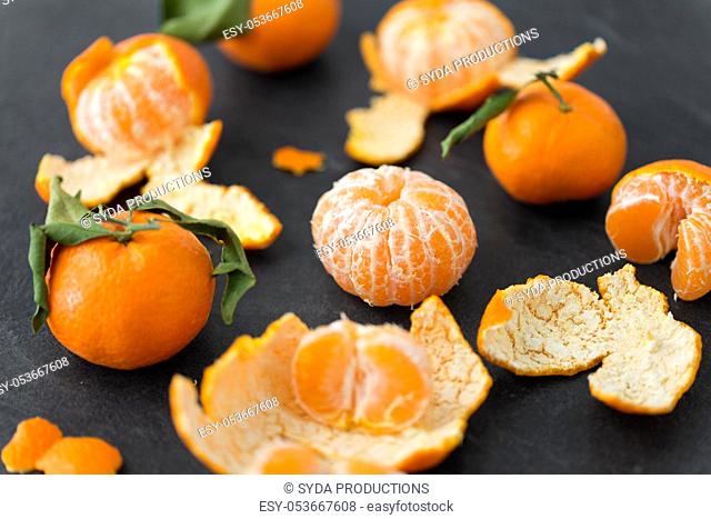 close up of peeled mandarins on slate table top