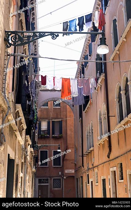 Narrow alley with taut clothesline from house to house in Venice, Italy