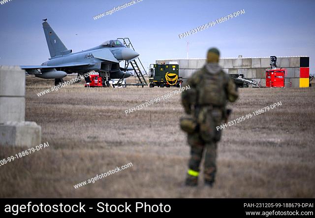 05 December 2023, Romania, Constanta: A Bundeswehr soldier stands in front of a German Eurofighter at Mihail Kogalniceanu airfield near Constanta (Romania)