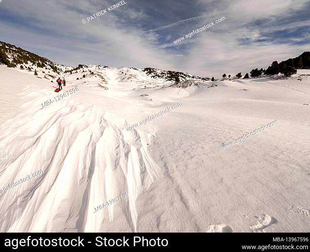 Two skiers on a ski tour with pulka material sledges through the nature reserve Réserve naturelle des Hauts Plateaux du Vercors