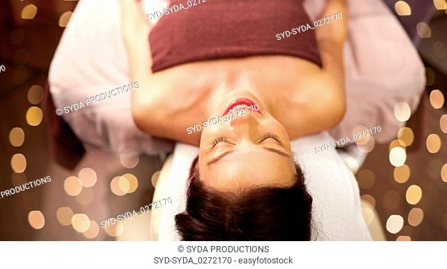 happy young woman lying at spa or massage parlor