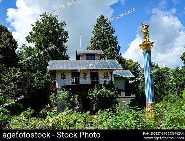 19 August 2020, Bavaria, Feldafing: The island villa, the so-called casino, and the white-blue glass column with the sculpture of a girl with parrot on the Rose...
