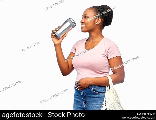 woman with tumbler and food in string bag