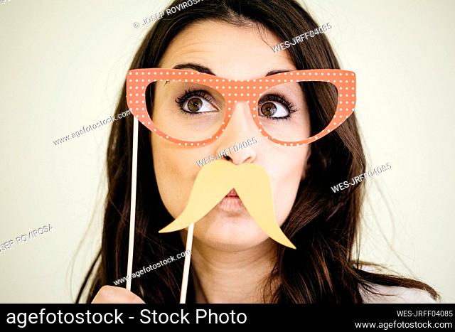 Portrait of young woman with comedy glasses and fake moustache