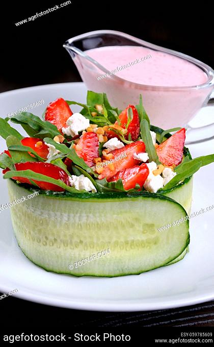 portion of strawberry salad with arugula and ricotta in cucumber