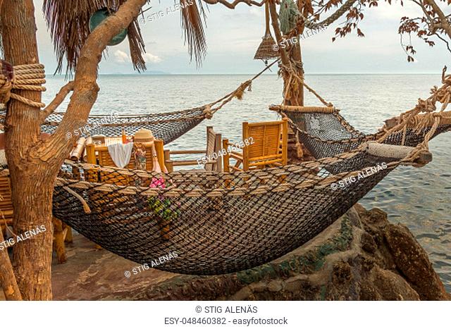 Hammocks hanging over a cliff at a Thai Restaurant and a table with female accessories, Haad Son, Koh Pangan, Thailand, May 08, 2016