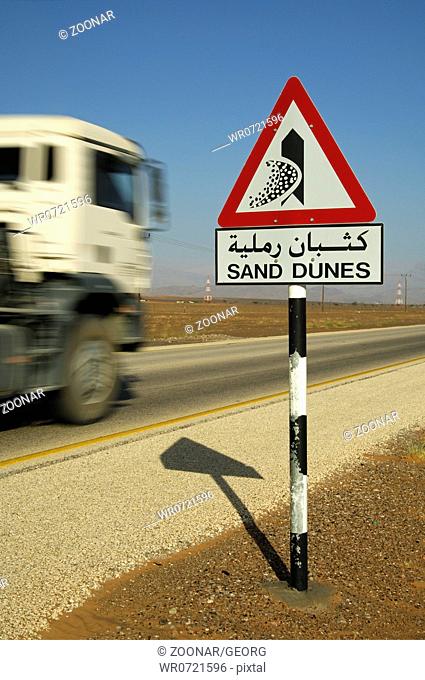 Road sign warning of shifting sand dunes, Oman