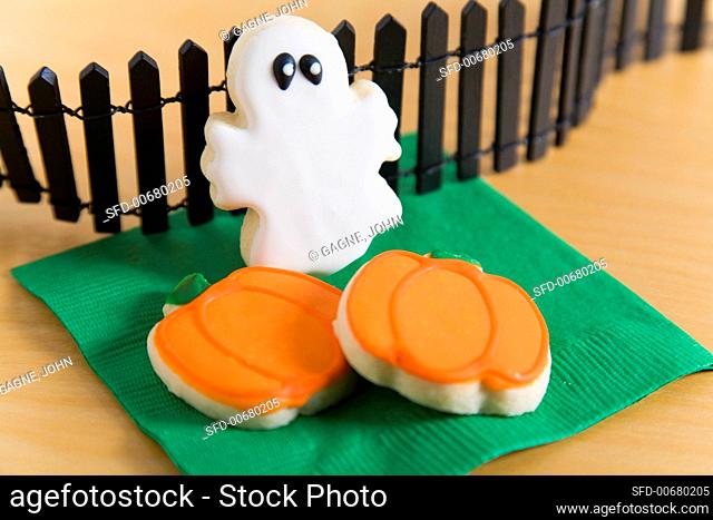 Two Pumpkin Cookies and a Ghost Cookie with Black Fence for Halloween