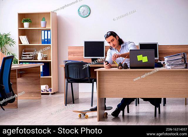 Young employee with skateboard in the office