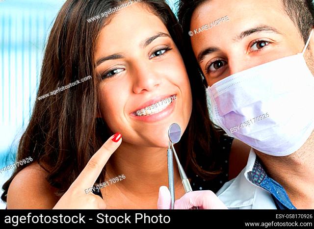 Close up portrait of Young girl with dentist pointing at mouth